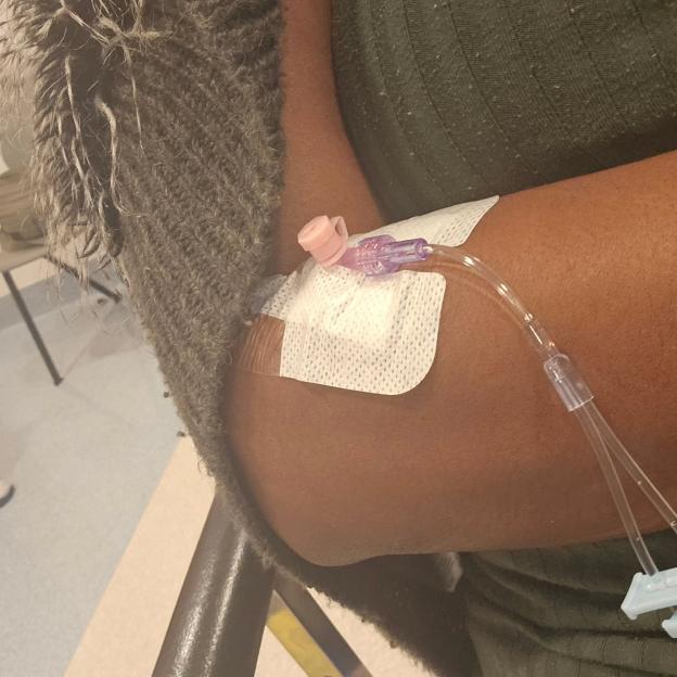 Person's arm with an IV line.