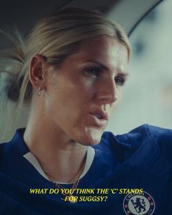 Close-up of a woman in a Chelsea football jersey, asking