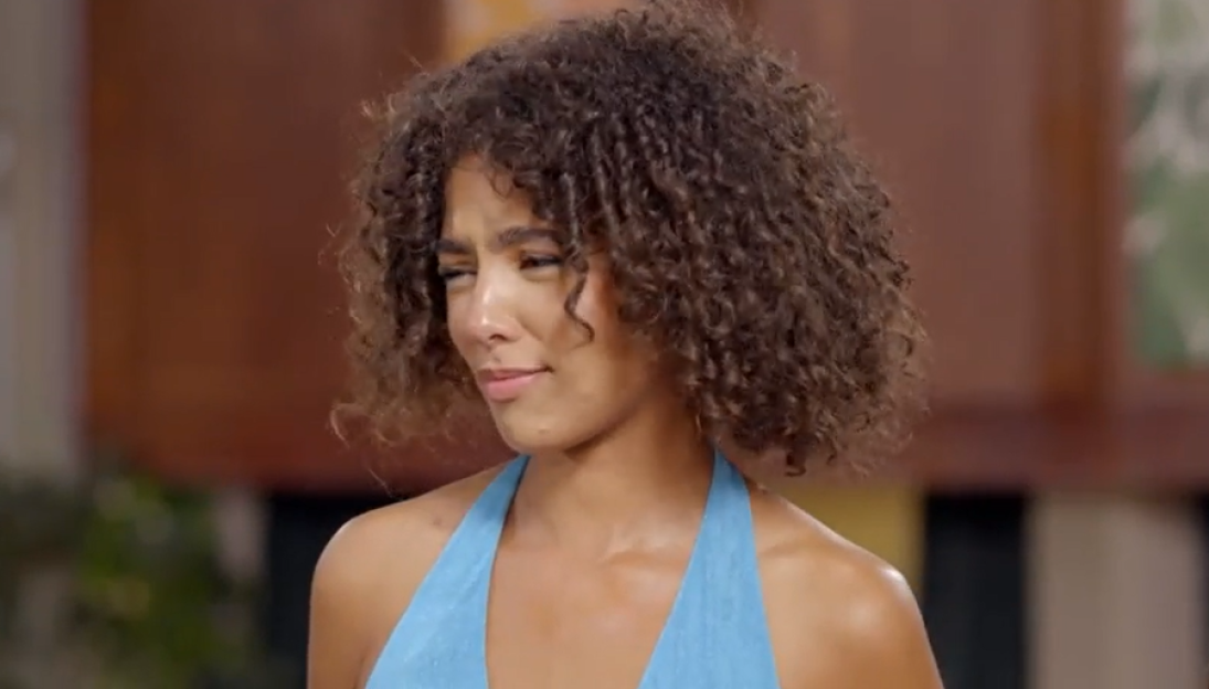 Woman with curly hair looking to the side.