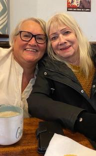 Two women sitting together at a table.
