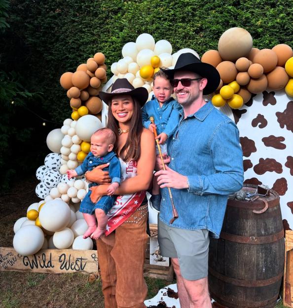 A family of four dressed in cowboy attire at a "Wild West" themed party.