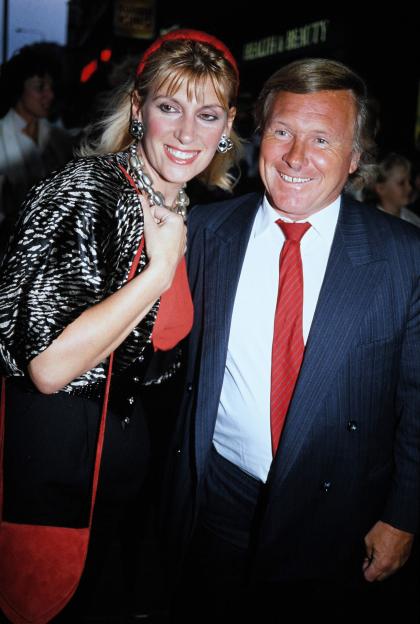 A man and woman posing in front of a health & beauty sign