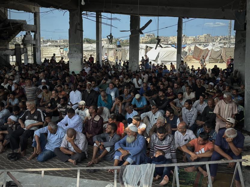Palestinians performing Friday prayers among the rubble of a mosque in Khan Yunis