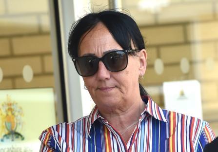 Head-and-shoulders photo of a woman wearing sunglasses and a striped shirt.