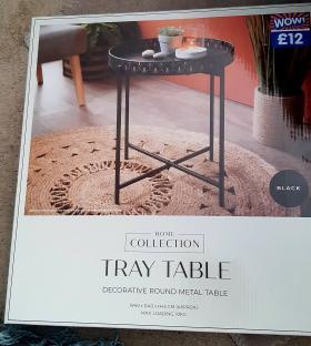Box showing a black metal tray table.