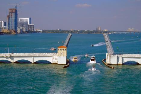 Venetian Causeway Bridge in Miami with boats passing through the open drawbridge.