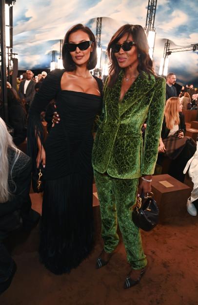 Maya Jama in a black dress and Naomi Campbell in a green velvet suit attend the Burberry Summer 2026 show.