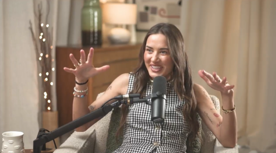 Woman speaking into a microphone during an interview.