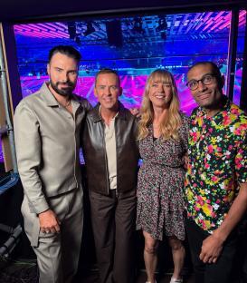 Group photo of four people backstage.