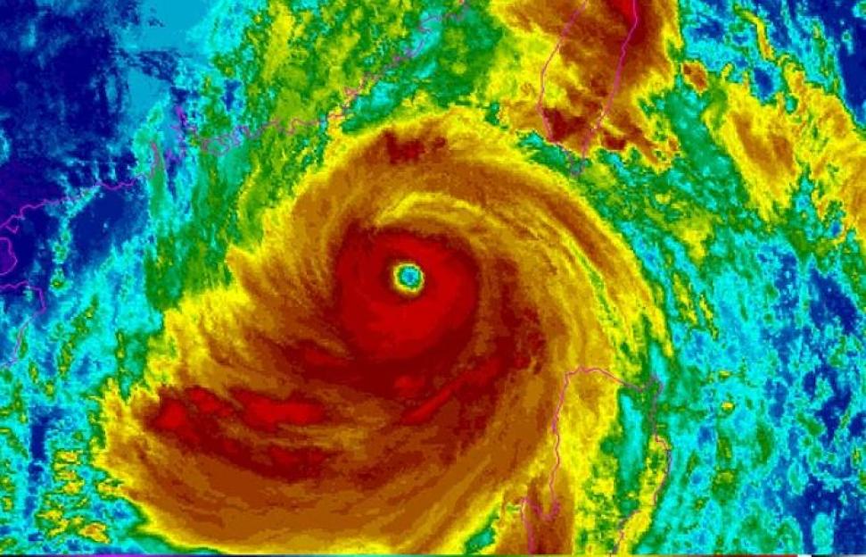 Satellite image showing a tropical cyclone with a clear eye, colored in shades of blue, green, yellow, orange, and red to indicate cloud top temperatures and storm intensity.