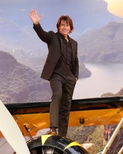 Tom Cruise waving from a biplane.