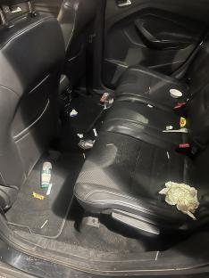 Messy backseat of a car.
