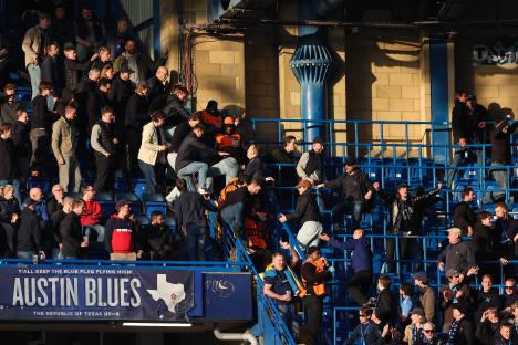 Djurgården fans moving past stewards at a soccer match.