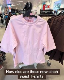 Pink cinch waist T-shirts on display in a store.