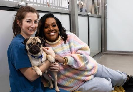 Alison Hammond and a vet holding a pug at Battersea Dogs and Cats Home.