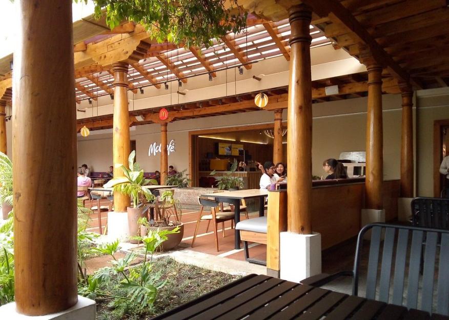 Patrons sitting at tables in a McDonald's McCafe patio.