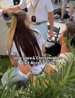 Jojo Siwa sitting on Chris Hughes' lap on Access Daily.