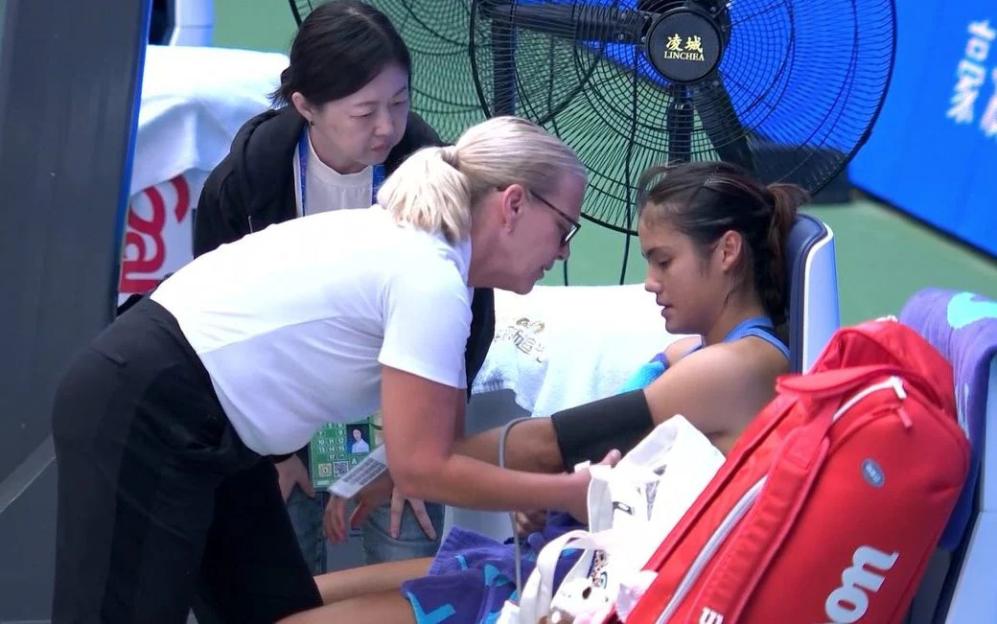Emma Raducanu receiving medical attention on the court at the Wuhan Open.