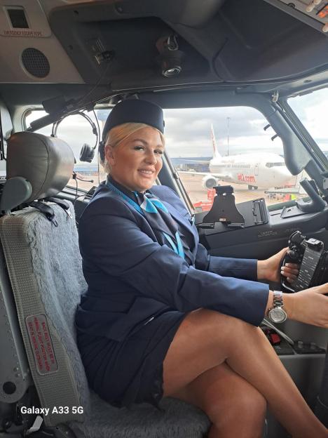 Karlene Warner, a flight attendant, smiling in a plane cockpit.