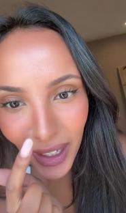 Close-up of Maya Jama demonstrating a beauty product.