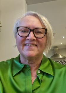 Woman in green shirt and glasses.
