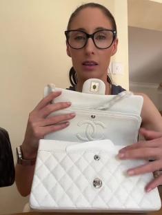 Woman holding up a white Chanel handbag.