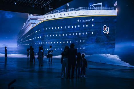 People viewing a large projection of the Titanic.