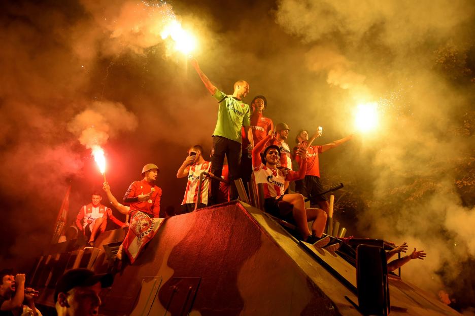 Red Star Belgrade fans celebrating on a tank with flares.
