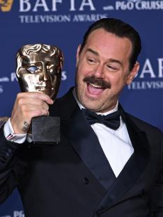 Danny Dyer holding a BAFTA Television Award.