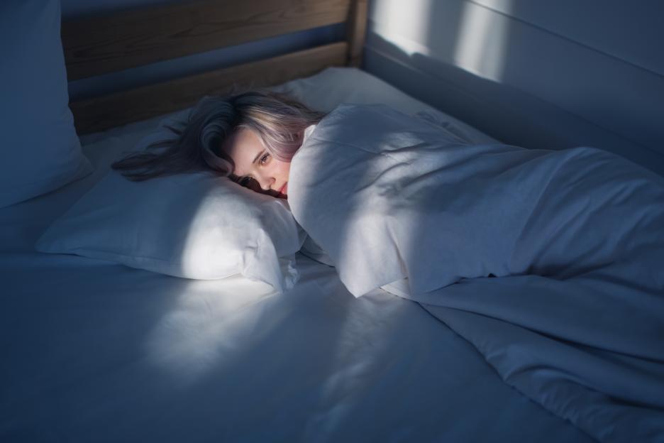 Blonde woman lying on bed.