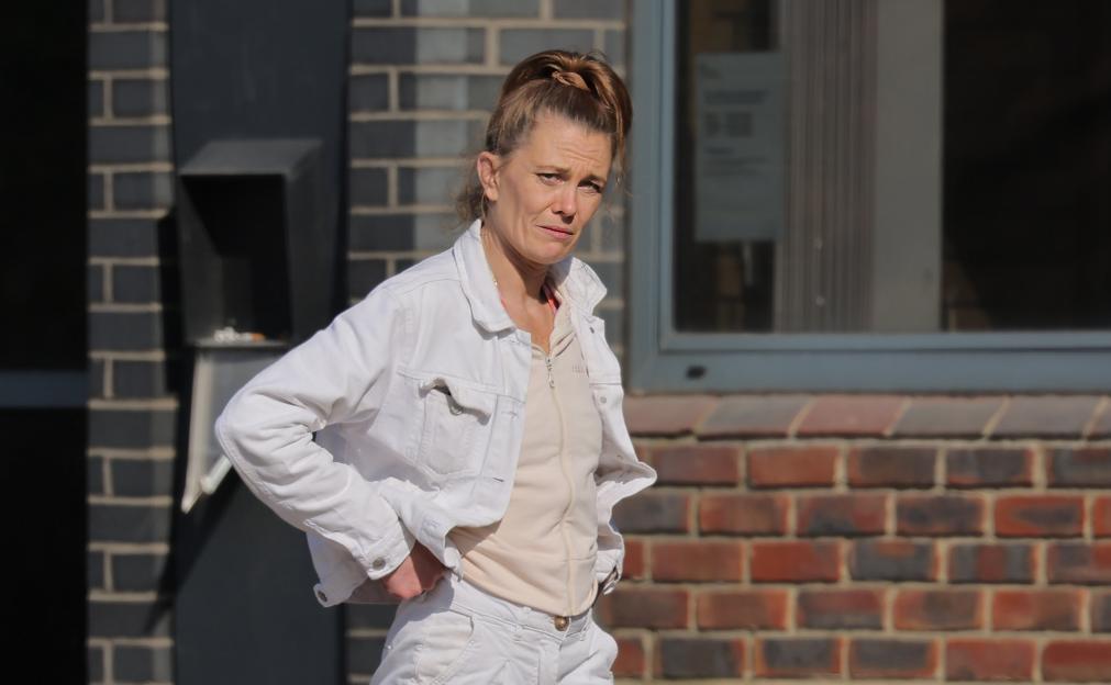 Woman in white jacket appearing in court.