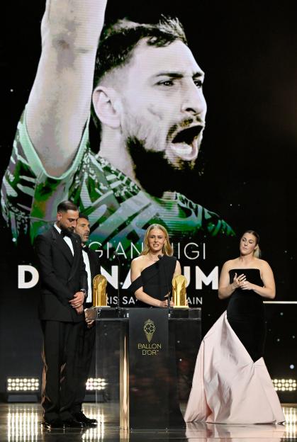 Hannah Hampton speaking on stage at the Ballon D'Or Ceremony with the Women's Yahsin Trophy, alongside Gianluigi Donnarumma, Gianluigi Buffon, and Mary Earps.