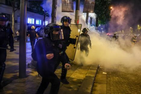 Riot police in smoke during a protest.