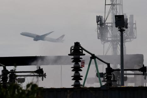 Plane taking off over a smoking electrical substation.