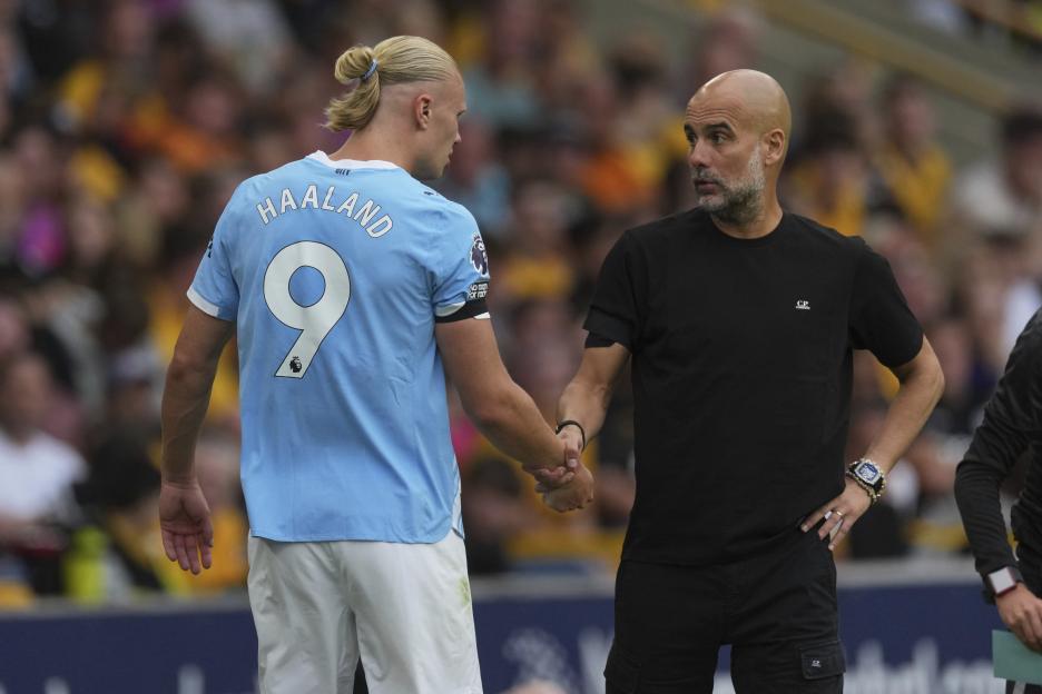 Pep Guardiola shaking hands with Erling Haaland.