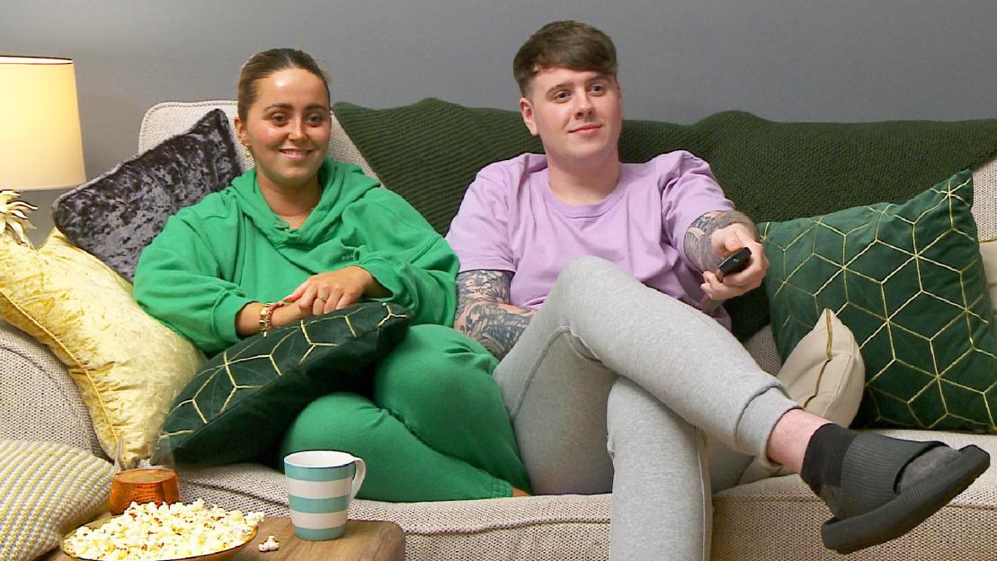 Roisin and Joe on a sofa, with Joe holding a TV remote.