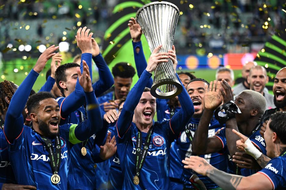 Chelsea FC players celebrating with the UEFA Conference League trophy.