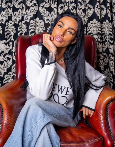 Katie Price sitting in a leather chair.