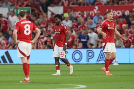 Three Nottingham Forest football players looking dejected on the pitch.