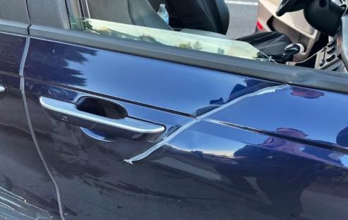 Scratched dark blue car door.