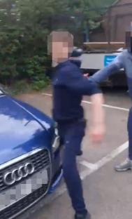 A teenager being confronted by another person near a car.