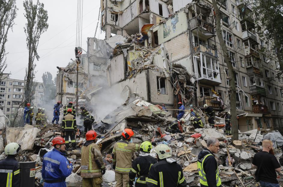 Rescue workers at the site of a damaged building.