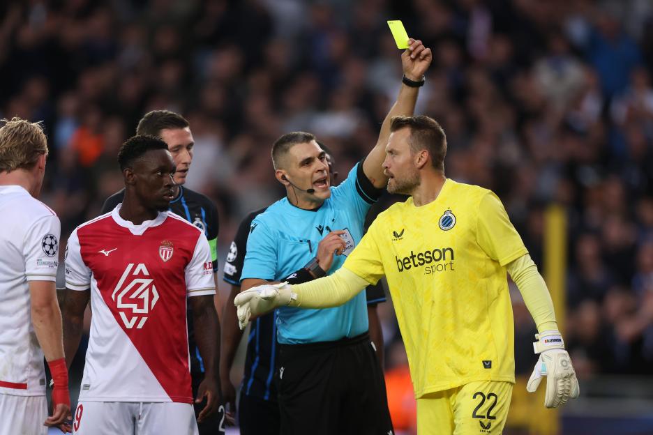 Referee Simone Sozza shows a yellow card to Simon Mignolet.