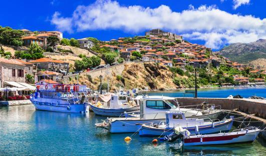 Mythimna (Molivos) harbor in Lesvos, Greece, with boats and a hilltop town.