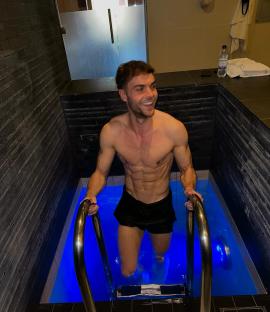 Man entering a blue plunge pool.
