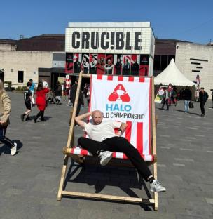 Man relaxing in a deck chair outside the Crucible Theatre during the Halo World Championship.