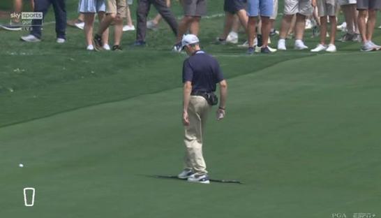 Golfer walking away from the green.