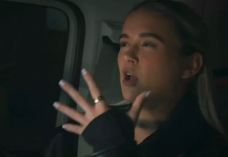 Woman speaking animatedly in a car.