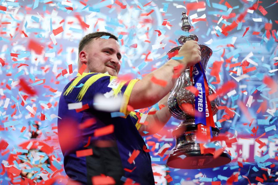 Luke Littler celebrating with the Phil Taylor Trophy after winning the World Matchplay.