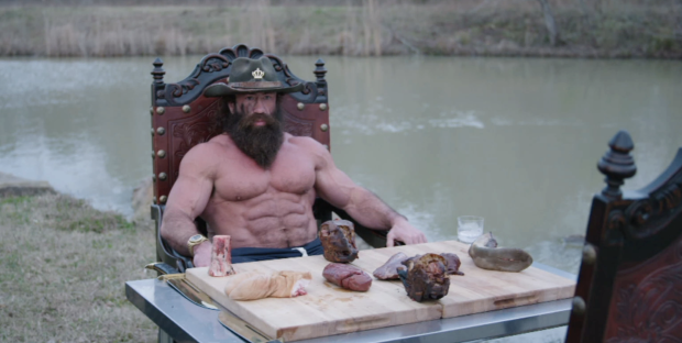 Brian Johnson, known online as the Liver King, holding a large piece of liver.